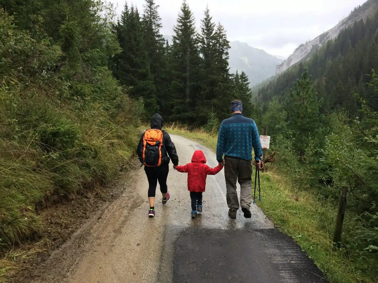 Famille en randonnée sur un sentier forestier avec sac à dos